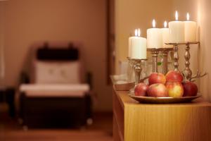 莱赫阿尔贝格Hotel Garni Schneider的桌上放着一碗苹果和蜡烛