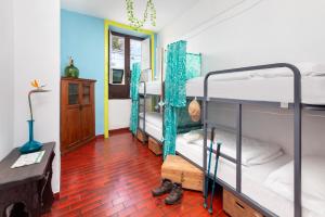拉拉古纳Patio Hostel的客房设有三张双层床,铺有红色瓷砖地板。