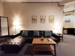 悉尼悉尼克雷西酒店的客厅配有黑色沙发和桌子