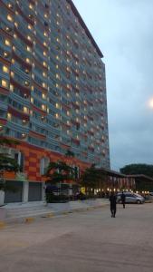 芝卡朗Apartemen Riverview Residence Jababeka at KiNGDOM Rent Apartment Solution的一座大型建筑,前面的人在步行