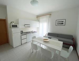 利多迪耶索罗Dainese Apartments, Casa Ester的厨房以及带桌子和沙发的客厅。