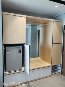 关丹Cozy Seaview Studio at Imperium residence Tanjung Lumpur Kuantan的厨房配有木制橱柜和冰箱。