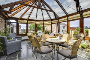 雅莱科瑞麦乐尔酒店的一个带桌椅的温室和一个玻璃屋顶