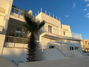 圣玛丽亚巴格诺Residence Valentina - Apartment Leonardo int 8的一座白色的建筑,前面有棕榈树