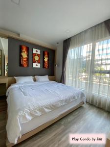 清迈Play Condo Chiang mai MAYA的一间卧室设有一张大床和一个大窗户