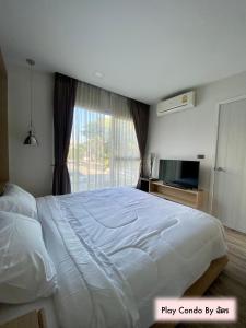 清迈Play Condo Chiang mai MAYA的卧室设有一张白色大床和一扇窗户。