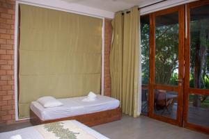 蒂瑟默哈拉默Breezy Lake的一间卧室设有一张床和一个带庭院的窗户。
