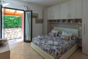 卡波利韦里Elbaloves Appartaments Villa的一间卧室设有一张床和一个滑动玻璃门