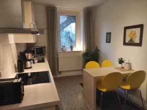 汉诺威菲罗所费维尔特尔公寓的厨房配有黄色的椅子和厨房桌子