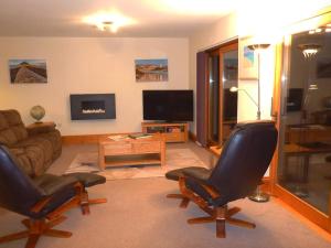纽基The Burrow at Woodlands的客厅配有两把椅子和一张沙发