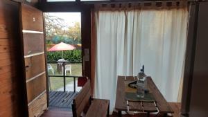 GualeguaychúCabañas Diamante的一间带木桌和窗户的用餐室