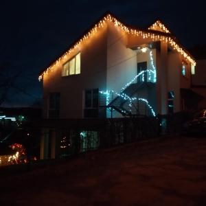 特鲁斯卡韦茨Сімейний відпочинок的旁边是一座带圣诞灯的房子