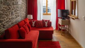 圣皮埃尔堡L'ancienne Poste - Maison Napoléon的客厅配有红色沙发和电视