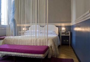 热那亚Hotel Colombo Genova的一间卧室配有一张大床和紫色长凳