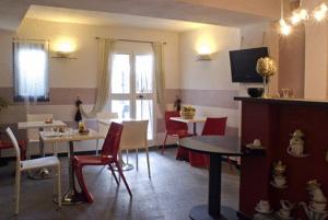 热那亚Hotel Colombo Genova的客厅配有桌子和红色椅子