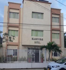 圣玛尔塔Blanco Mar Hotel的前面有栅栏的建筑