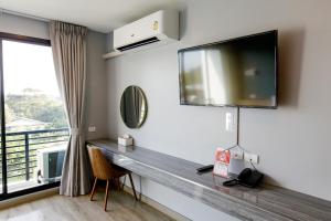拉差汶里Le Lert Hotel Ratchaburi的客房设有书桌、电视和窗户。