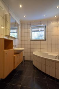朗根费尔德MAXAlpin Appartements的浴室设有2个水槽、浴缸和镜子
