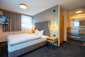 朗根费尔德MAXAlpin Appartements的酒店客房设有一张大床和一台电视。