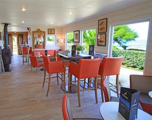 塞比瑞尔Le Theven的一间带橙色桌椅的餐厅和一个庭院