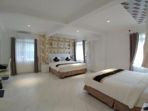 茂物Chevilly Resort & Camp的一间白色的大卧室,配有两张床和窗户