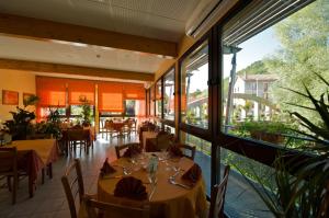 沃雷Logis Hotel Restaurant Auberge Les Rives de l'Arzon的餐厅设有桌椅和大窗户。