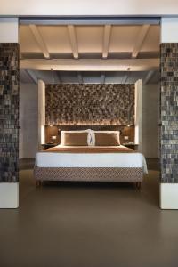 阿尔扎凯纳斯卡佐西亚卡鲁酒店的一间卧室设有一张带砖墙的大床