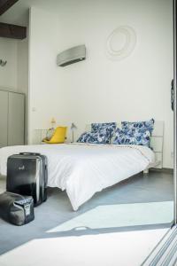 圣马西敏·拉塞Sous les oliviers - Piscine chauffée à débordement- Studios climatisés的卧室配有一张床,地板上放着一个行李箱