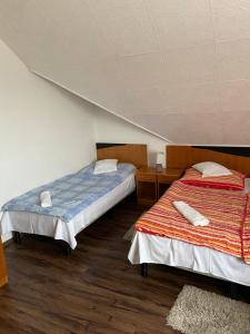 克尔门德Teke Panzió的一间客房内配有两张床的房间