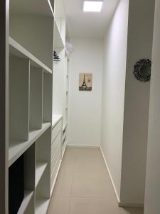 戈亚尼亚Metropolitan Sidney Smart Style的一条带白色架子和白色墙壁的走廊