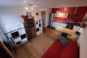 维勒讷沃Libellules的一间带红色沙发的客厅和一间厨房