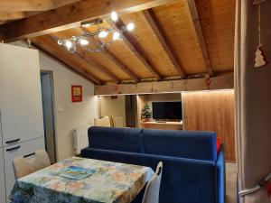 拉夏贝尔德邦达Chalet la sapiniere的客厅配有桌子和蓝色沙发