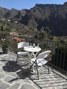 马斯卡Live Masca - Estudio casas morrocatana Tenerife的山景庭院设有一张白色的桌子和两把椅子