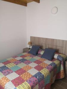 马斯卡Live Masca - Estudio casas morrocatana Tenerife的一间卧室配有一张带五颜六色被子的床