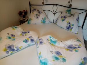 巴特奥塞Ausseer Kleeblatt的一张带蓝色和白色枕头的床