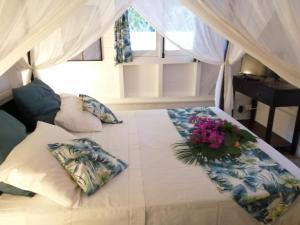 黑角Blue Kaz Caraïb的一间卧室,床上放着鲜花