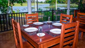蒂瑟默哈拉默Double Lake View Tissa & Safari的一张木桌,上面有椅子和盘子
