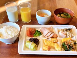浦安Henn na Hotel Maihama Tokyo Bay的桌上的饭盘,配上米饭和橙汁