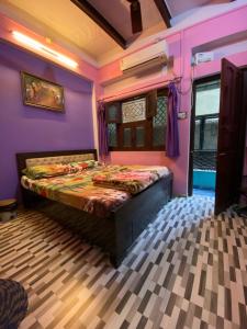 瓦拉纳西玛丽戈尔德旅馆的紫色客房内的一间卧室,配有一张床