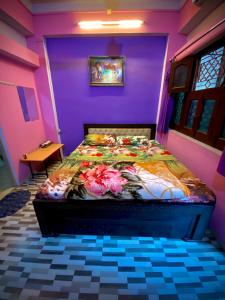 瓦拉纳西玛丽戈尔德旅馆的紫色客房内的一间卧室,配有一张床