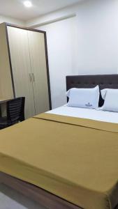 门格洛尔Bhumi Residency的一间卧室配有一张大床和一个橱柜