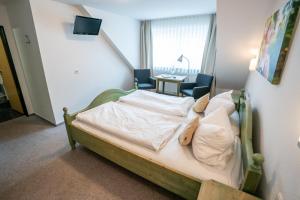 兰格瑙Hotel-Gasthof zur Linde的一间卧室配有一张带两把椅子和一张桌子的床。