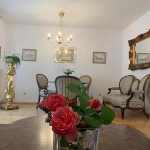 巴登Amadeus Apartment的客厅里一张桌子上的花瓶,上面有玫瑰花