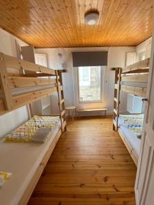图伊JACOB'S HOSTEL TUI的客房设有两张双层床和木制天花板。
