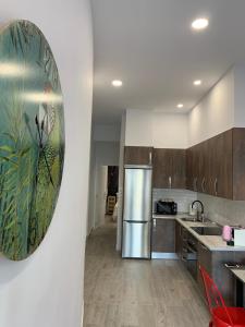 马德里T-Homes - Fuencarral的厨房配有不锈钢用具,墙上挂有绘画作品