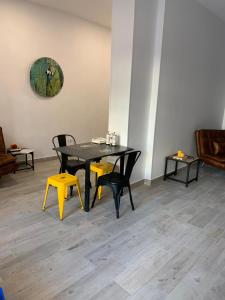 马德里T-Homes - Fuencarral的一间用餐室,配有一张黑桌子和黄色椅子