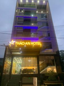 顺化THẢO AN HOTEL Huế的上面有 ⁇ 虹灯标志的高楼