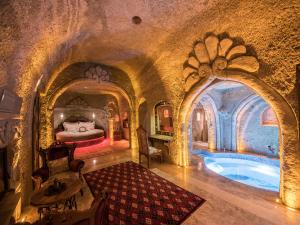 内夫谢希尔Kapadokya Hill Hotel & Spa (12+)的一间设有床铺的房间和一个游泳池
