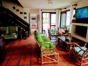托雷斯Pousada Morada Da Prainha的客厅设有绿色椅子和壁炉