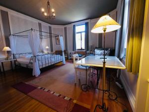 斯帕L'Étape Fagnarde - Bed, Breakfast & Sauna的客房设有两张床和一张带台灯的桌子。